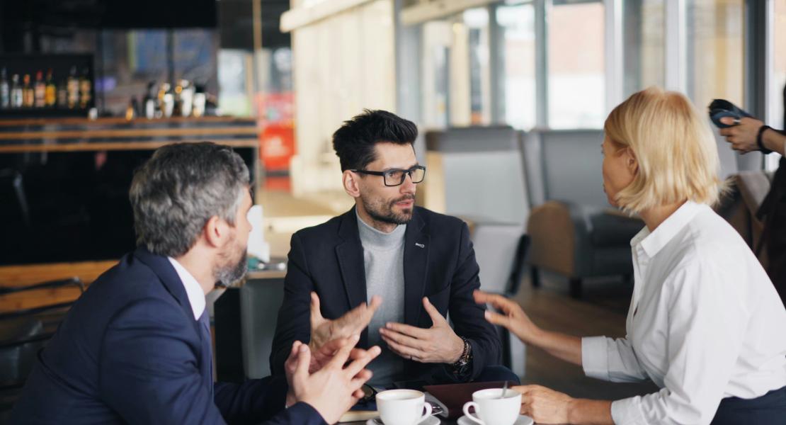 Image of group of people sitting around a table talking