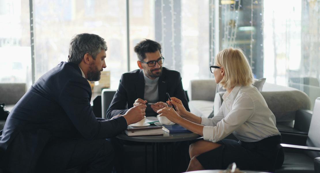 Image of two men and a woman networking.